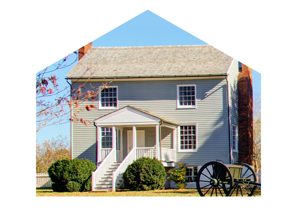 Gray house with old wagon in front