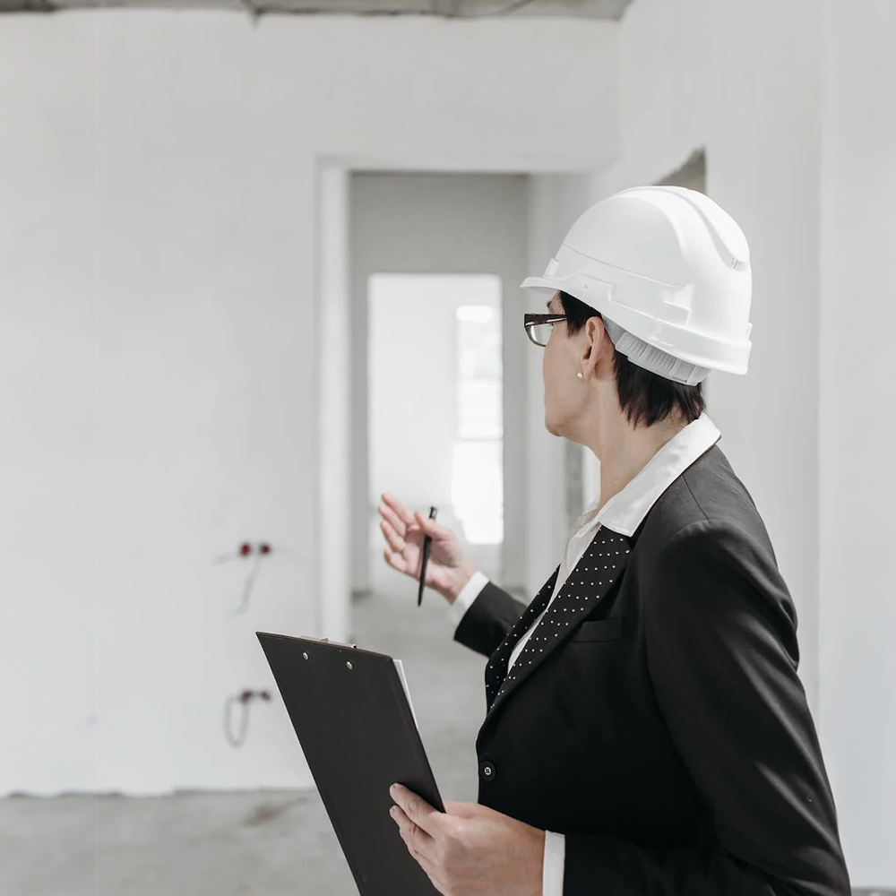 woman wearing a hard hat inside a home under construction